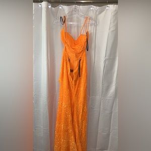 From a local prom dress store is sparkly and orange and is a size 8